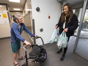 Maintaining an appropriate distance, University of Ottawa med student, Sam Buchanan, delivers groceries to Jean Millar who is unable to get out to do her own shopping.