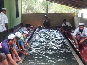 In this picture taken on March 24, 2020, Muslim Rohingya refugees perform ablution before praying in a mosque at Kutupalong refugee camp in Ukhia. Sewage-soaked alleys and cramped canvas and bamboo shacks that house one million Rohingya refugees in Bangladesh are a horrifying scene for experts watching the coronavirus pandemic creep closer. (Photo by SUZAUDDIN RUBEL / AFP)