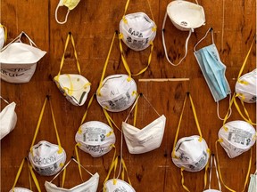 FILES - Protective masks bearing the names of medical staffers and nurses are pictured pinned to a wall