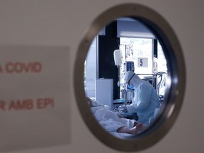 A healthcare worker wearing a protective suit attends to a COVID-19 coronavirus patient at the Intensive Unit Care (ICU) of the Vall d'Hebron Hospital in Barcelona on April 6, 2020. - Spain declared a fourth consecutive drop in the number of coronavirus-related deaths with 637 over the past 24 hours, the lowest number in nearly two weeks.