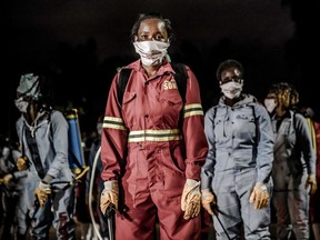 Members of a privately-funded NGO working with county officials wearing protective gather on April 15, 2020, during the dusk-to-dawn curfew imposed by the Kenyan Government, to receive instructions on how to fumigate and disinfect the streets and the stalls at Parklands City Park Market in Nairobi to help curb the spread of the COVID-19 coronavirus. - With a current official number of 225 confirmed coronavirus cases, Kenya has so far cordoned off the capital and parts of its coastline and imposed a curfew and other social distancing measures as part of the country efforts to control the spread of the virus.