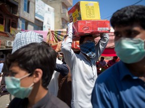 A labourer carries boxes of dates at a market just before the start of Ramadan during a government-mandated nationwide lockdown in Rawalpindi, Pakistan.