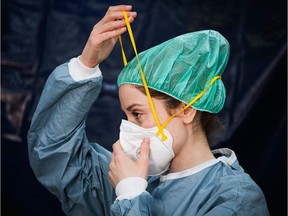 29-year-old doctor, Shayma Radi, put on her personal protective equipment (PPE) in a tent on the grounds of the Sophiahemmet private hospital, before she performs tests on a patient to see if she has symptoms of COVID-19 on April 22, 2020 in Stockholm.