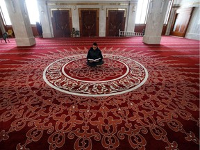 A Palestinian Muezzin, who calls Muslims to prayer, reads the holy Koran in an almost empty mosque in Gaza City on the first Friday prayers of the holy fasting month of Ramadan on April 24, 2020 as mass prayers are suspended due to the COVID-19 coronavirus pandemic.