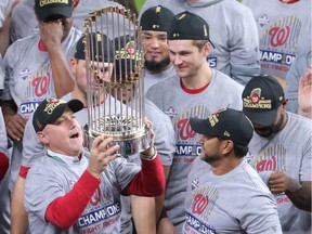 Washington Nationals general manager Mike Rizzo hoists the Commissioners Trophy after the 2019 World Series.