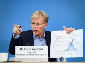 Team leader of the joint mission between World Health Organization (WHO) and China on COVID-19, Bruce Aylward shows graphics during a press conference at the WHO headquarters in Geneva on February 25, 2020.