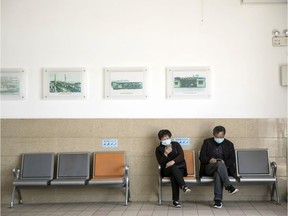 People wearing protective masks sit on a bench in the waiting lounge of the Shanghai Ferry terminal in Shanghai, China, on Thursday, April 2, 2020. China has officially declared its epidemic contained after reported new cases fell to zero on March 19, but there's growing concern over a second wave both domestically and in travelers arriving at its border.