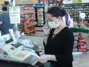 Johanna Ramirez works in her grocery store in Fort Lupton, Colorado, where she is concerned that not enough customers are taking precautions, like wearing masks, to stop the spread of the coronavirus.