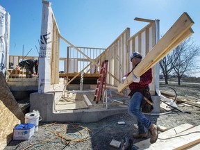 Charles Rochfort, left, and Jonathan Grenier work on a home as Quebec lifts the ban on residential construction due to the COVID-19 pandemic Monday April 20, 2020 in Deux-Montagnes, Que..