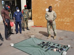 The man arrested in Accra, Ghana, for impersonating a Canadian Armed Forces officer is seen in uniform in front of guns and other items police said he carried.