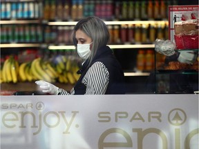 An employee of a supermarket wears a protective mask and gloves during the global coronavirus disease (COVID-19) outbreak in Vienna, Austria, April 6, 2020.