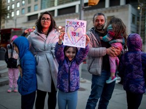 A family watches as Toronto Police and the city's front-line responders pay tribute to healthcare workers along University Avenue as the number of coronavirus disease (COVID-19) cases continue to grow in Toronto, Ontario, Canada April 19, 2020.