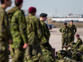 Canadian Forces members wait to board busses which will take them to CFB Borden where they will wait in preparation to respond to the coronavirus disease (COVID-19) as well as other emergencies at the request of all three levels of government, in Toronto, Ontario, Canada April 6, 2020.  REUTERS/Carlos Osorio ORG XMIT: GGGTOR101