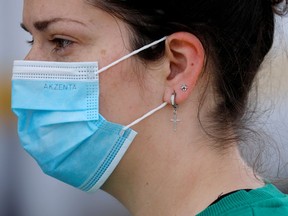 A woman wears a protective face mask.