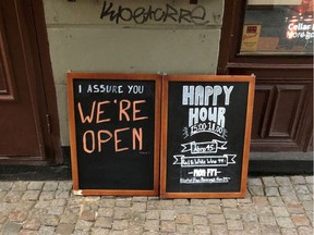 FILE PHOTO: A sign assures people that the bar is open during the coronavirus outbreak, outside a pub in Stockholm, Sweden March 26, 2020.