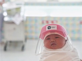 A newborn baby is seen wearing a protective face shield during the coronavirus disease (COVID-19) outbreak at the Praram 9 hospital in Bangkok, Thailand, April 9, 2020.