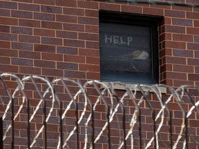 Signs made by prisoners pleading for help are seen in a window of Cook County Jail in Chicago, Illinois, U.S., April 9, 2020 amid the coronavirus disease (COVID-19) outbreak.