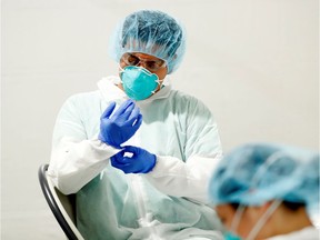 Healthcare workers don personal protective equipment.