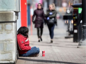 A homeless person looks for assistance on Bank Street.