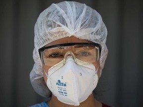 A member of a mobile medical team, wearing personal protective equipment (PPE), stands for a photograph after performing COVID-19 rapid tests on patients in San Juan de Lurigancho neighborhood of Lima, Peru, on Friday, April 17, 2020.