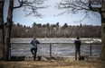 People watch the chunks of ice flow down the Ottawa River at Bate Island on Saturday, April 4, 2020.