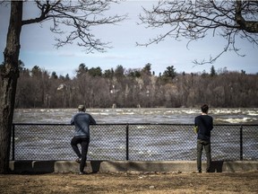 People watch the chunks of ice flow down the Ottawa River at Bate Island on Saturday, April 4, 2020.