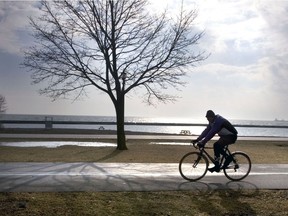 A typical spring day: Puddles, budding trees and a cyclist riding along the trail.
