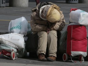 A homeless person huddles with some belongings in Toronto.