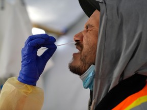 FILE PHOTO: Provincial health workers perform coronavirus disease (COVID-19) nasal swab tests on Raymond Robins of the remote First Nation community of Gull Bay, Ontario, Canada April 27, 2020. Picture taken April 27, 2020. REUTERS/David Jackson/File Photo ORG XMIT: FW1