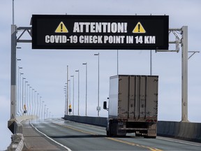 A sign indicates that provincial health department workers will stop traffic that has crossed the Confederation Bridge in Cape Jourimain, N.B., on March 22.