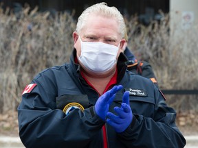 Ontario Premier Doug Ford applauds as he hands out prepared meals to frontline health-care workers at a hospital in Toronto on April 24.