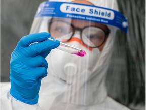 A healthcare worker holds a test kit.