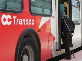A passenger boards an OC Transpo bus by the rear door in mid-April.