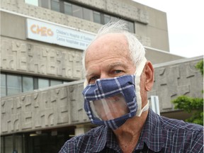 Keith McGruer models one of the special masks he and his wife, Nancy, are making at CHEO on Monday.