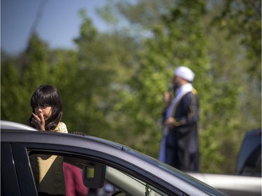 OTTAWA -- May 23, 2020 -- A young girl peeks out of the vehicles sunroof during a special drive-in Eid prayer that was held at the Ottawa Mosque on Northwestern Ave, Saturday, May 23, 2020.