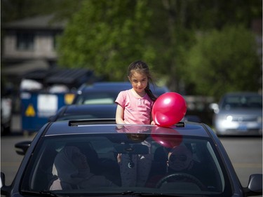 OTTAWA -- May 23, 2020 -- A young girl peeks out of the vehicles sunroof during a special drive-in Eid prayer that was held at the Ottawa Mosque on Northwestern Ave, Saturday, May 23, 2020.