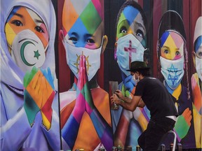Brazilian mural artist Eduardo Kobra works on his recent work "Coexistence".