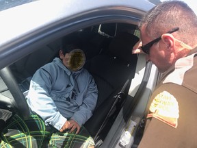 An officer is shown speaking to a five-year-old boy who was pulled over after driving his family's car on the highway in Weber County near Ogden, Utah on May 4, 2020 in this photo released by the Utah Highway Patrol.