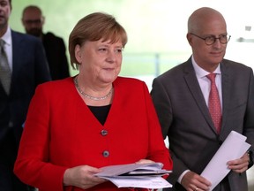 German Chancellor Angela Merkel and Peter Tschentscher, Mayor of Hamburg arrive for a press conference at the Chancellery in Berlin on May 6, 2020 after holding a video conference with the leaders of the Federal states on easing the lockdown restrictions during the novel coronavirus COVID-19 pandemic.