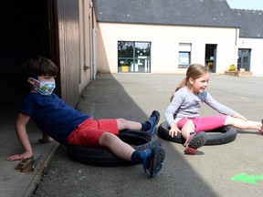 Children play in the school yard of the Alix de Bretagne school in Saint-Aubin-du-Cormier, on May 7, 2020, as the schools in France are to gradually reopen.