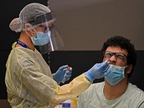 Health workers check passengers who arrived on an Emirates Airlines flight from London at   Dubai International Airport on May 8, 2020 amid the coronavirus Covid-19 pandemic.