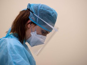 A physiotherapist attends to a patient who recovered from COVID-19 at the Clinica CEMTRO in Madrid on May 22, 2020.