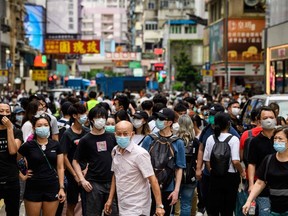 Protesters look towards a group of riot police in the Mongkok district of Hong Kong on May 27, 2020, as the city's legislature debates over a law that bans insulting China's national anthem.