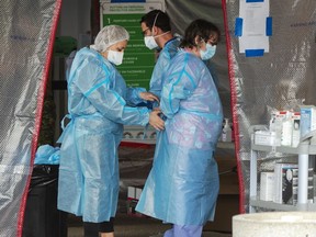 Healthcare workers put on protective equipment before entering the Vigi Mount Royal CHSLD senior's residence in Montreal, Friday, May 15, 2020.