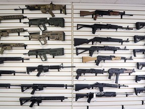 In this Oct. 2, 2018 photo, semi-automatic rifles fill a wall at a gun shop in Lynnwood, Wash. The federal government is poised to ban a variety of assault-style rifles.