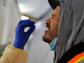 FILE PHOTO: Provincial health workers perform coronavirus disease (COVID-19) nasal swab tests on Raymond Robins of the remote First Nation community of Gull Bay, Ontario, Canada April 27, 2020.