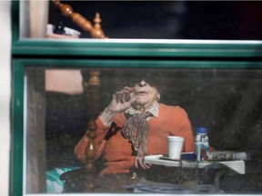 FILE PHOTO: A resident waves from her room, inside a seniors' long-term care facility.