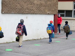 Green dots are placed in the schoolyard to help students keep distancing as schools outside the greater Montreal region begin to reopen their doors amid the coronavirus disease (COVID-19) outbreak, in Saint-Jean-sur-Richelieu, Que., on May 11.