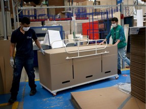 Employees of the company "ABC Display" move a cardboard hospital bed that they manufacture, amid the coronavirus disease (COVID-19) outbreak in Bogota, Colombia May 21, 2020.