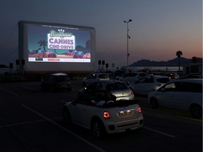 FILE PHOTO: People sit in their cars to watch the movie "E.T. the Extra-Terrestrial" by Steven Spielberg at a drive-in cinema at la Pointe Croisette, during the coronavirus disease (COVID-19) outbreak, in Cannes, France May 20, 2020.